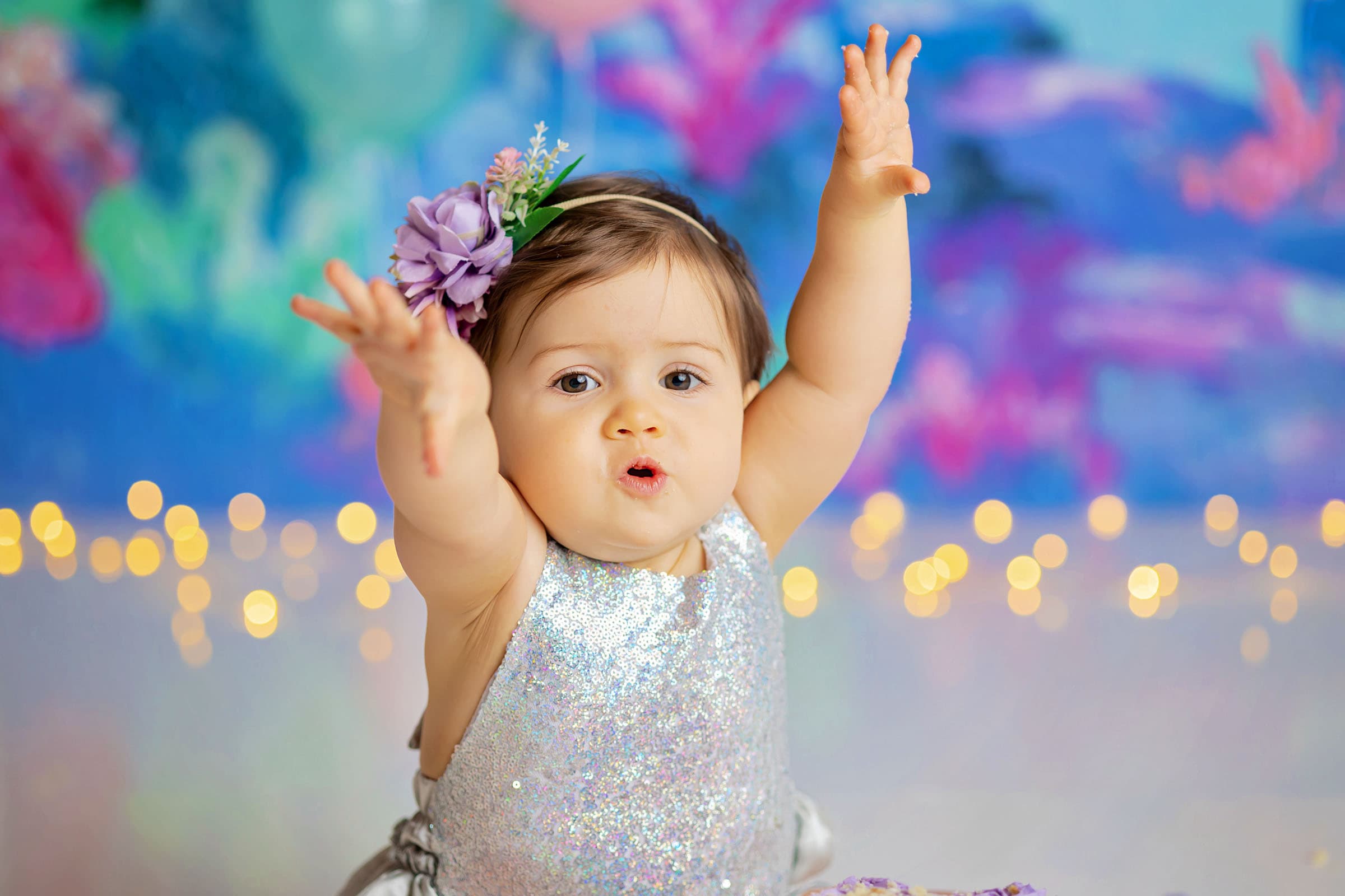Portrait of a baby girl holding her hands up